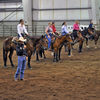 Riders on their makeover mustangs receiving instructions during a competition.