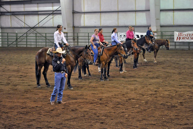 Riders on their makeover mustangs receiving instructions during a competition.