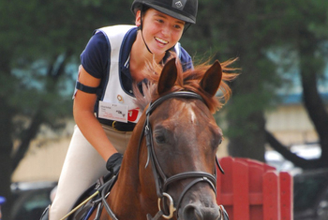A happy pony club member and her pony participate in a competition.