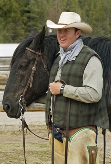 Young man ready to ride his horse in cowboy outfit.