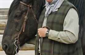 Cowboy taking care to keep horse calm before mounting him for a ride.