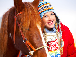 Happy young woman because daily once-over reveals a healthy horse.