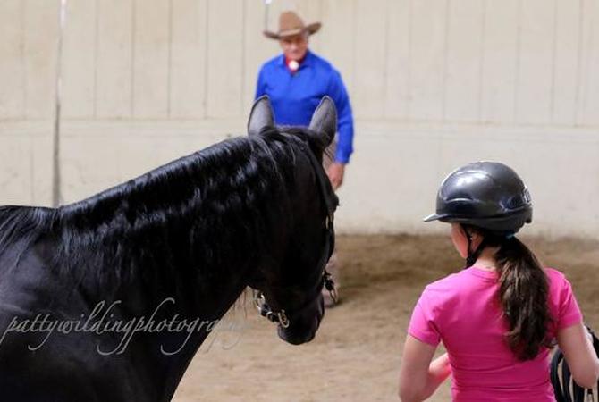 Monty Roberts teaching young girl his training techniques.