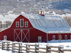 Red horse barn in a snowy winter setting.