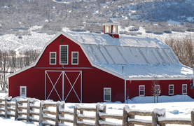 Red horse barn in a snowy winter setting.