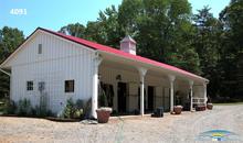 A colorful Horizon Structures shedrow barn with an over hang.