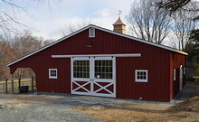 A small Horizon Structures barn with center aisle and large overhang.