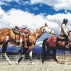 Julie Goodnight riding her horse Annie and ponying Gunner.