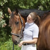 Girl using positive reinforcement while training horse.