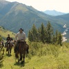Glenn Stewart leading a group riding their horses on a mountain trail.