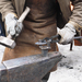A farrier at work making a custom horse shoe.