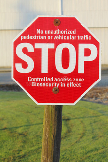 Red and white biosecurity warning stop sign.