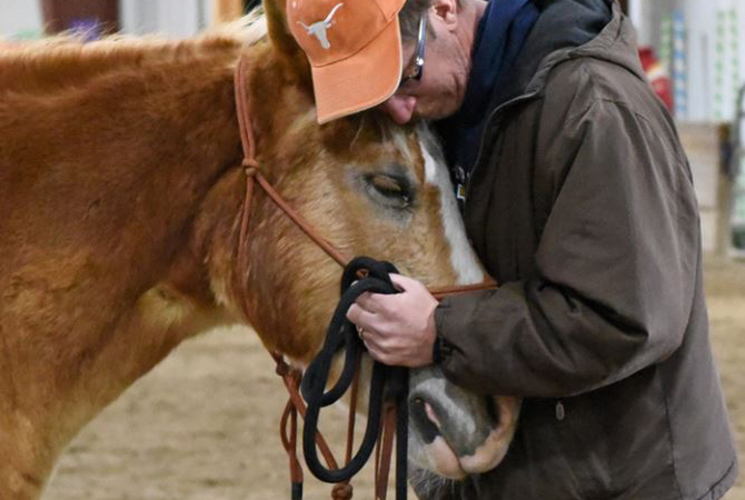 Veteran embracing and enjoying close contact with his therapy horse.