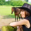 Lady in black hat enjoying time with horses.