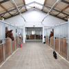 Interior of a large horse barn showing stalls for horses and aisle for dogs!