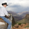 Young man on horse enjoying scenic views of Grand Canyon.