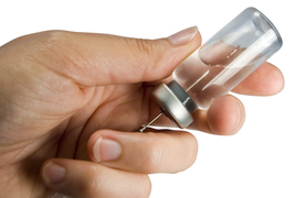 Getting ready to give vaccination by filling syringe.