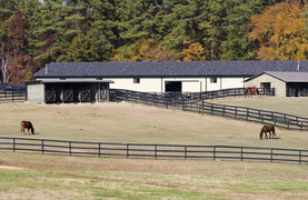 A wll-planned barn with corrals, paddock, pasture, and storage areas.