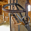 A bridle with bit hanging on a barn post.