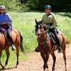 Horseback riders wearing appropriate helmets.