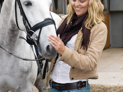Woman getting horse ready for training by studying his reactions.