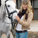 Woman getting horse ready for training by studying his reactions.