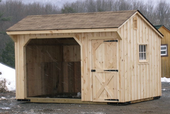 A three-sided wood run-in shed to protect horses during cold winter weather.